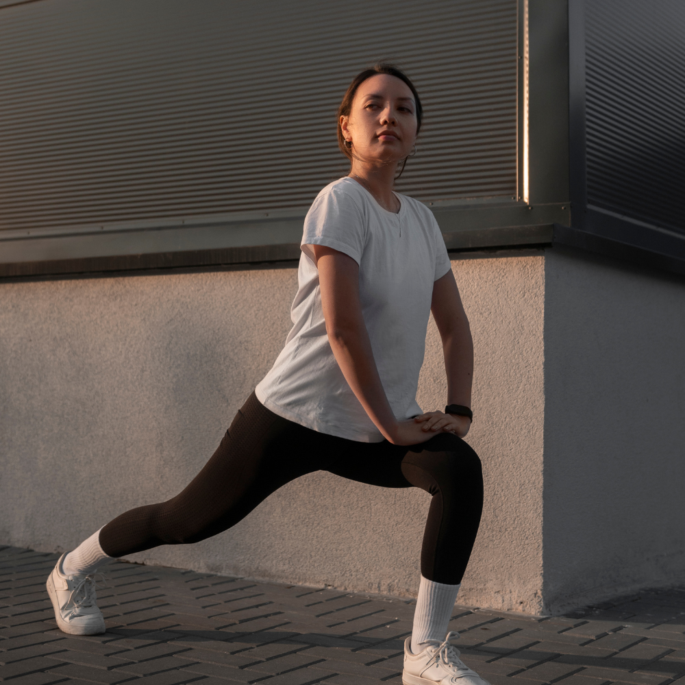 Person stretching outdoors against a building wall

